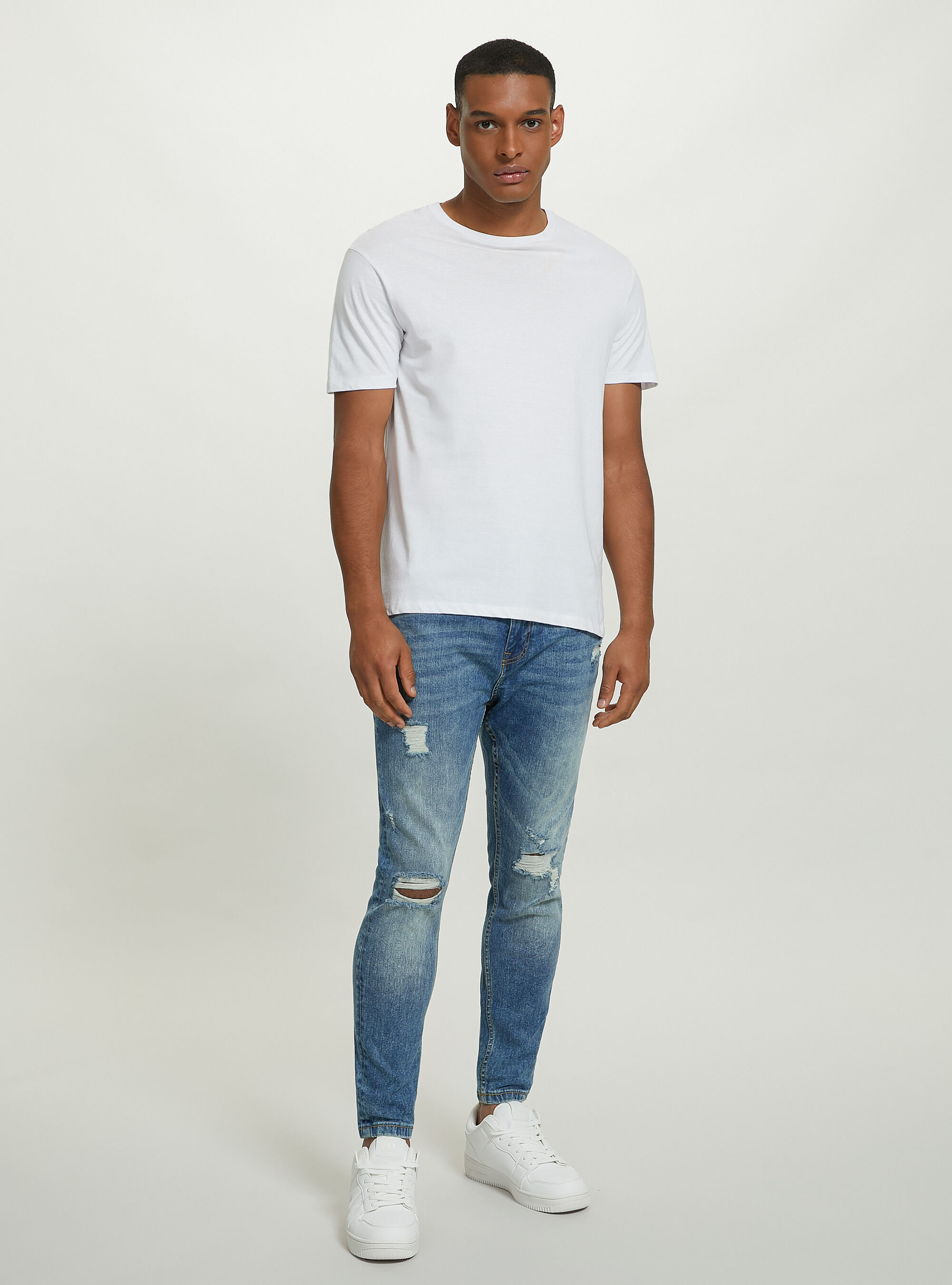 Stretch denim carrot fit jeans with rips