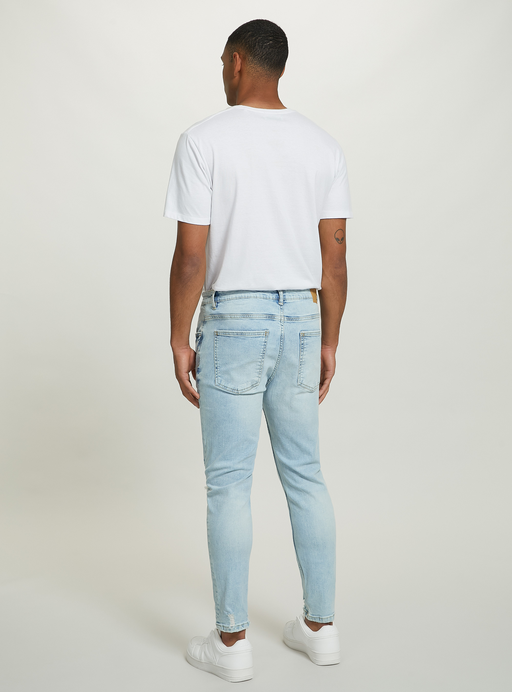 Jeans carrot fit in denim stretch con rotture Jeans carrot fit in denim stretch con rotture