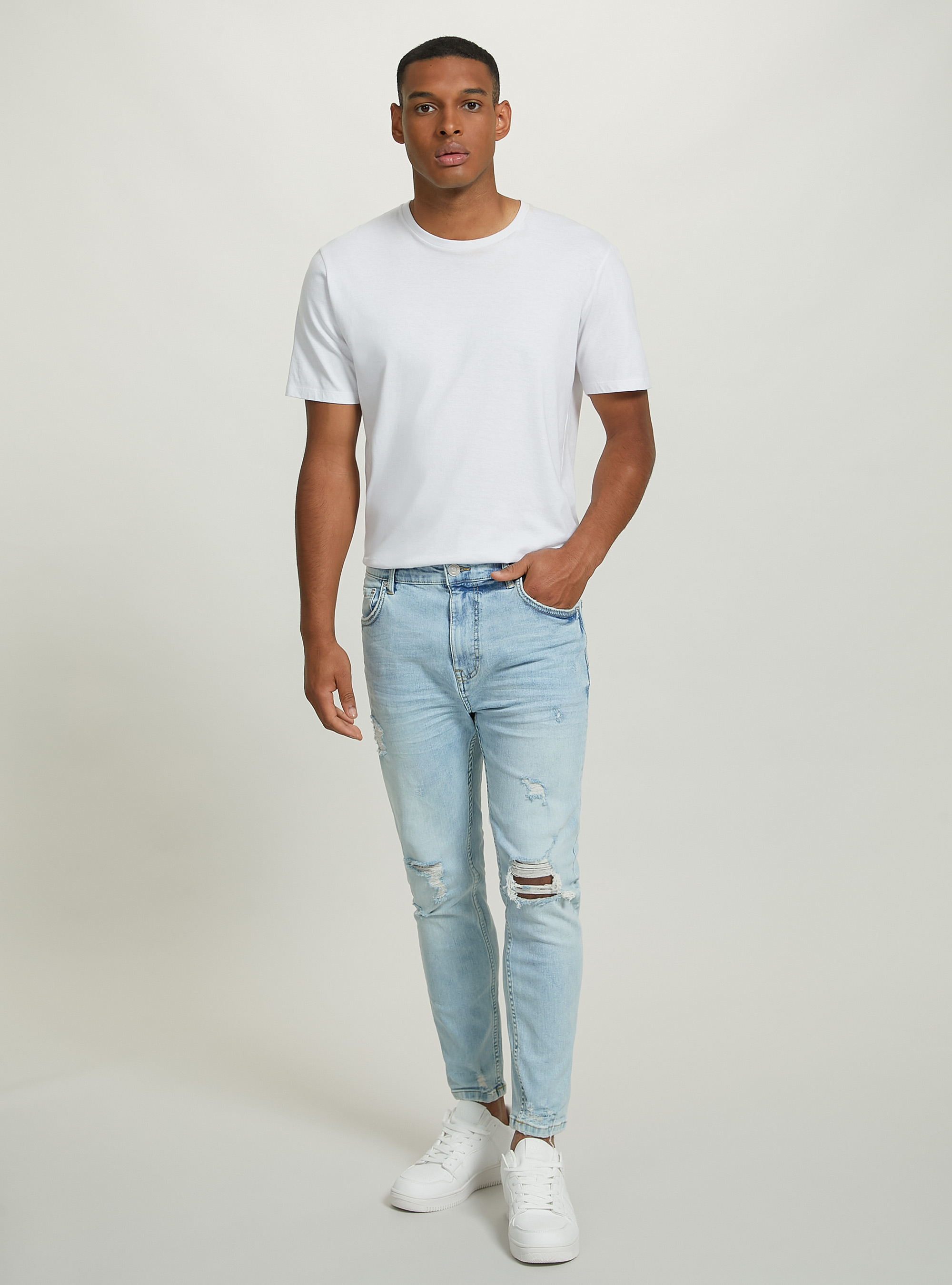Jeans carrot fit in denim stretch con rotture Jeans carrot fit in denim stretch con rotture